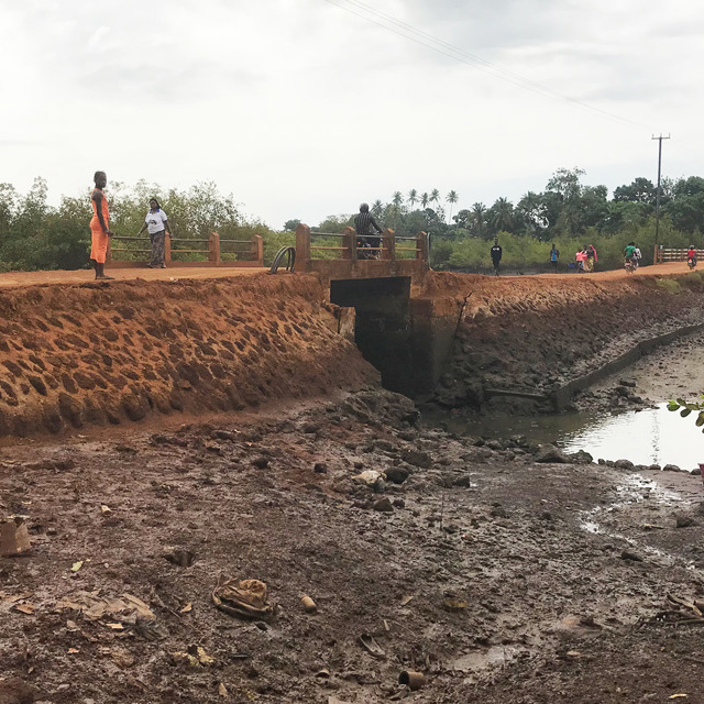Bruin pad met kleine brug en enkele staande mensen